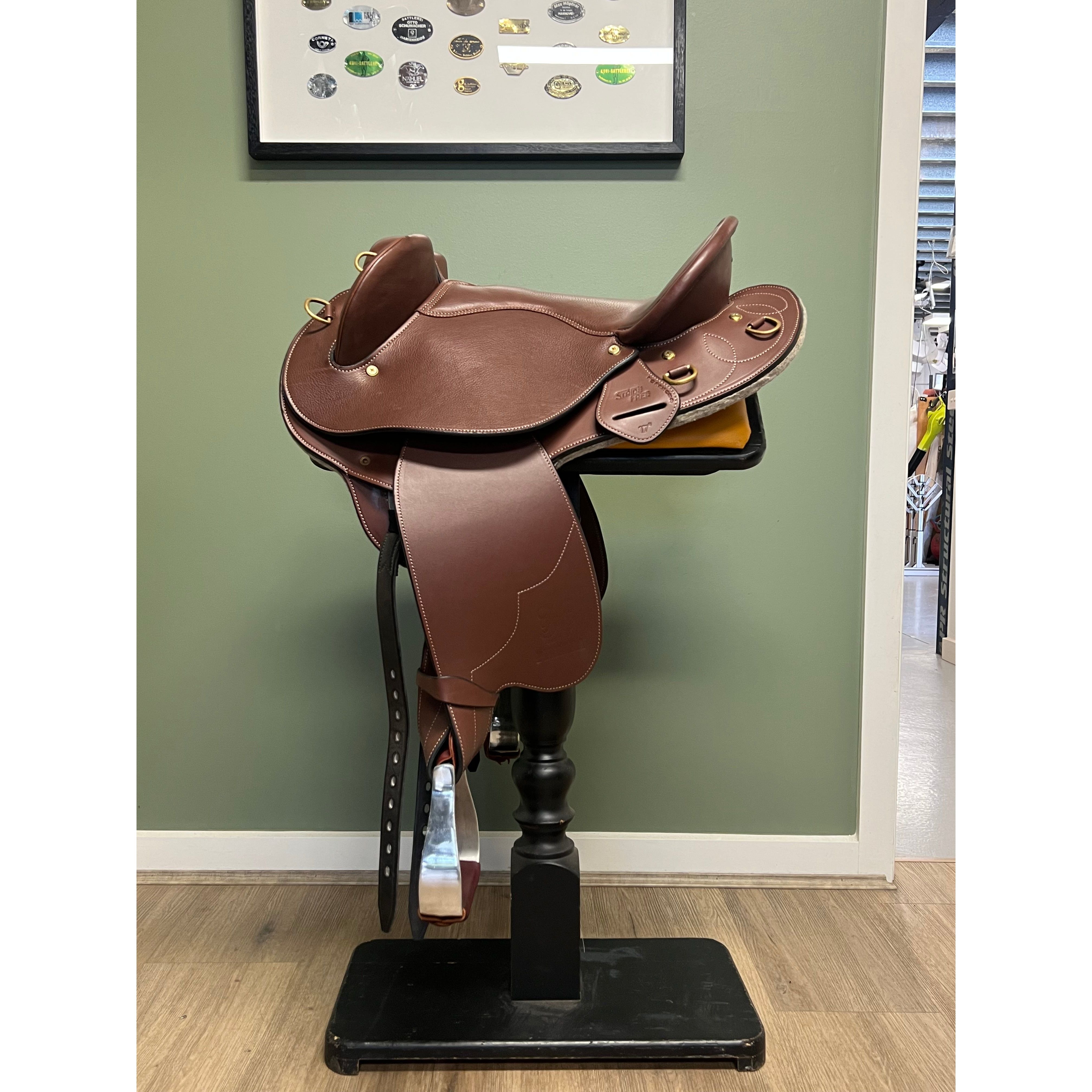 A brown StrideFree Pilbara saddle displayed on a saddle stand 